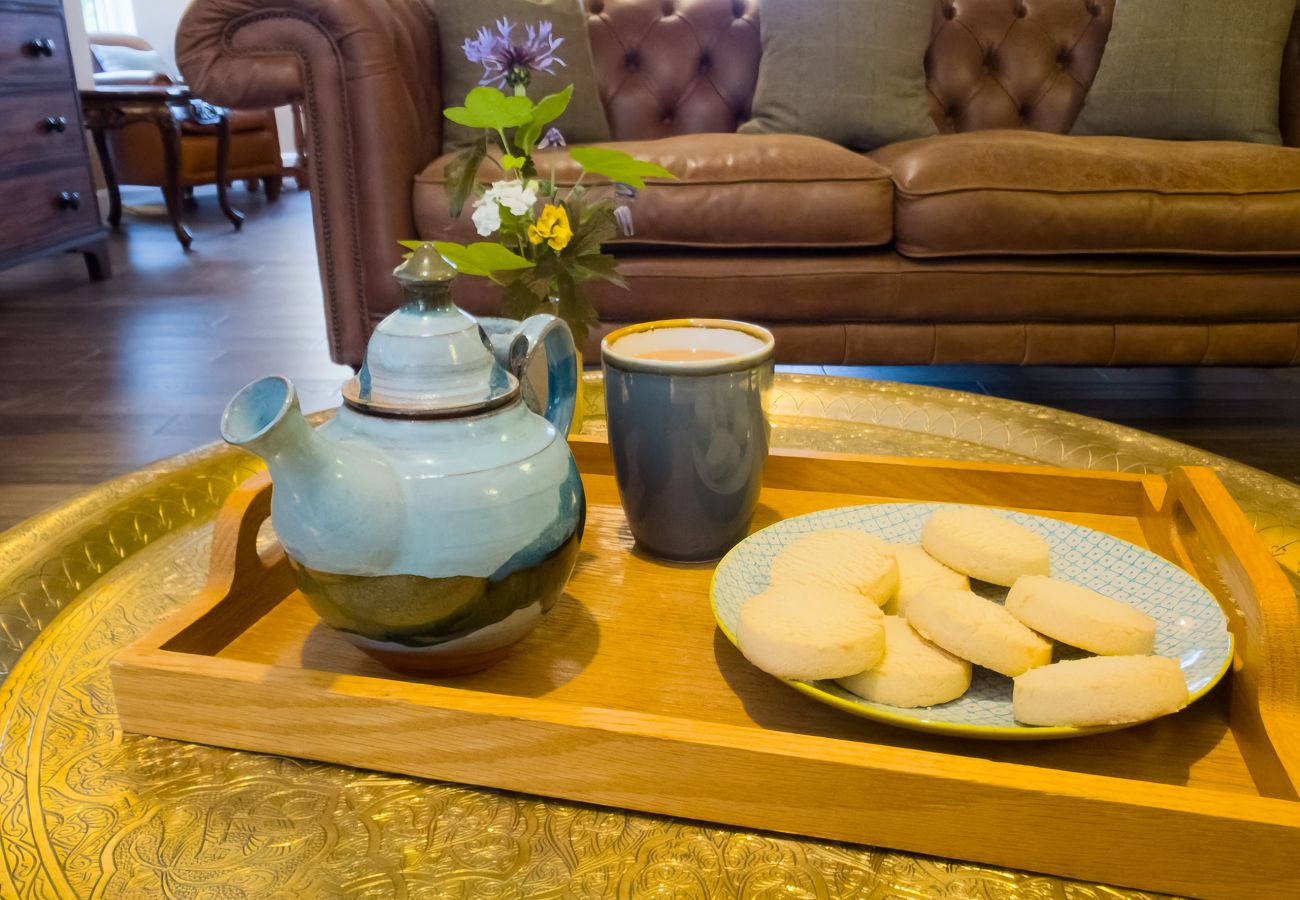 Cosy sitting area with leather Chesterfield sofa at Lynwilg House Highland group holiday home