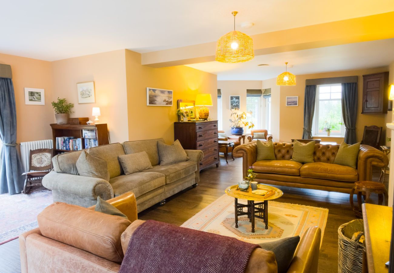 Spacious lounge with multiple sofas at Lynwilg House large Highland group holiday home