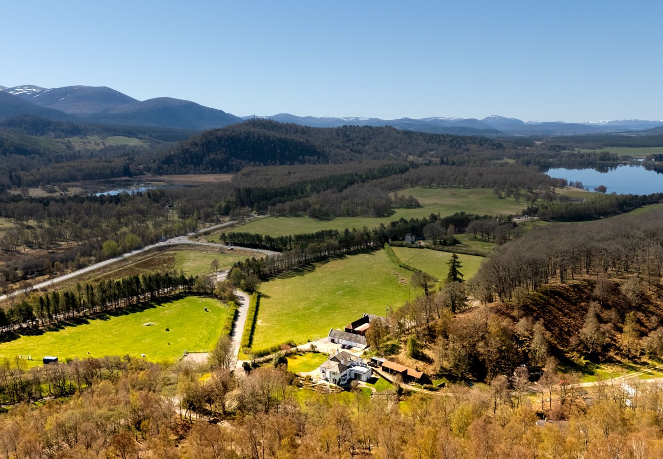 Aerial view of Lynwilg House estate with Cairngorm mountains and Highland valley in the background