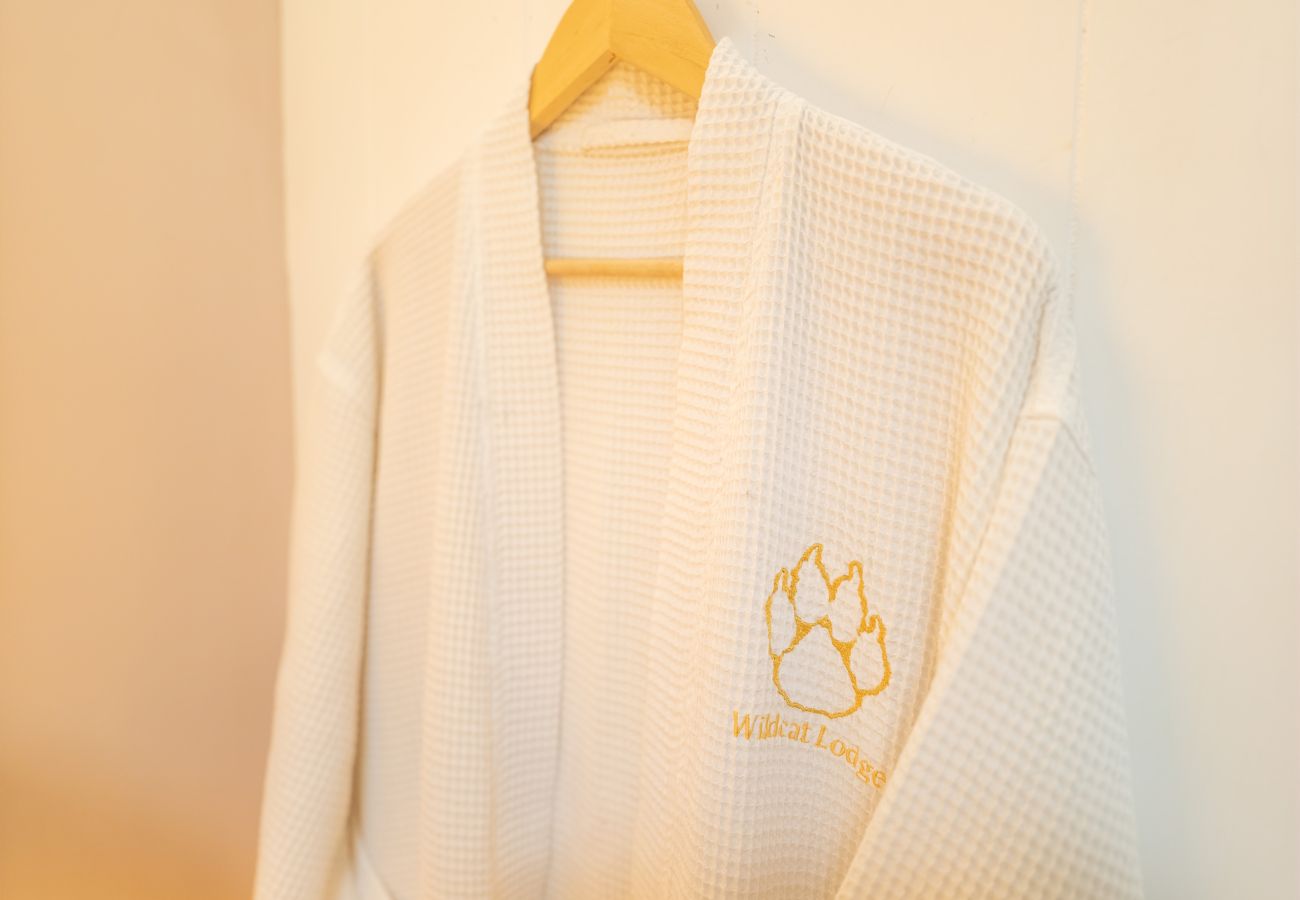 Embroidered Wildcat Lodge waffle bathrobes hanging ready for guests at this Cairngorms couples retreat