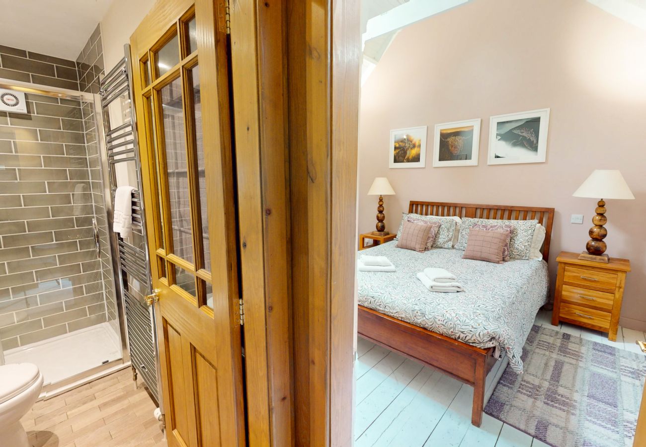 Double bedroom with adjoining tiled shower room at Wildcat Lodge, a couples lodge near Boat of Garten
