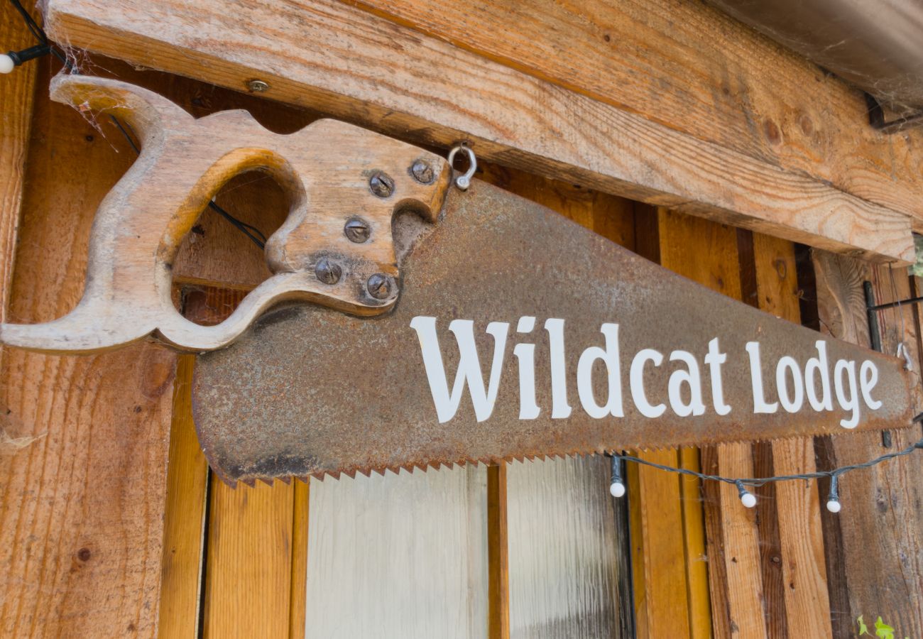Hand-painted Wildcat Lodge sign on an old saw blade hung under the eaves of the lodge, Cairngorms