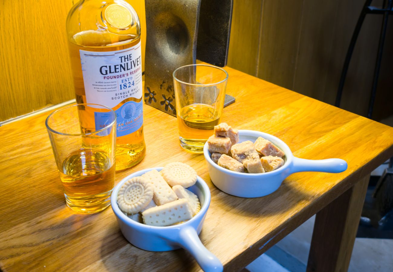 Whisky glasses, shortbread and tablet on a wooden table inside Wildcat Lodge near Boat of Garten