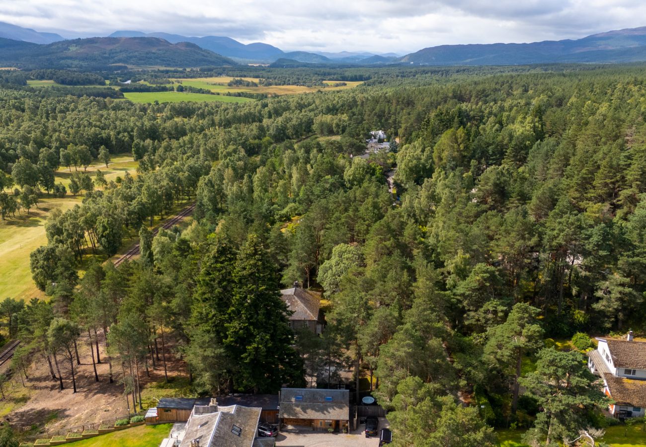 Aerial view over pine forest and farmland towards the Cairngorm mountains near Boat of Garten