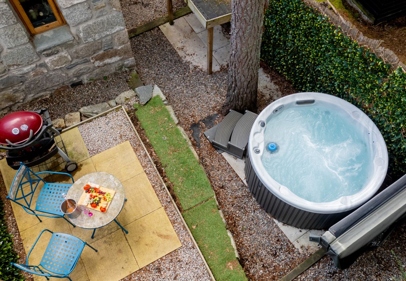 Enclosed garden with hot tub, barbecue and bistro table for two at Wildcat Lodge near Boat of Garten