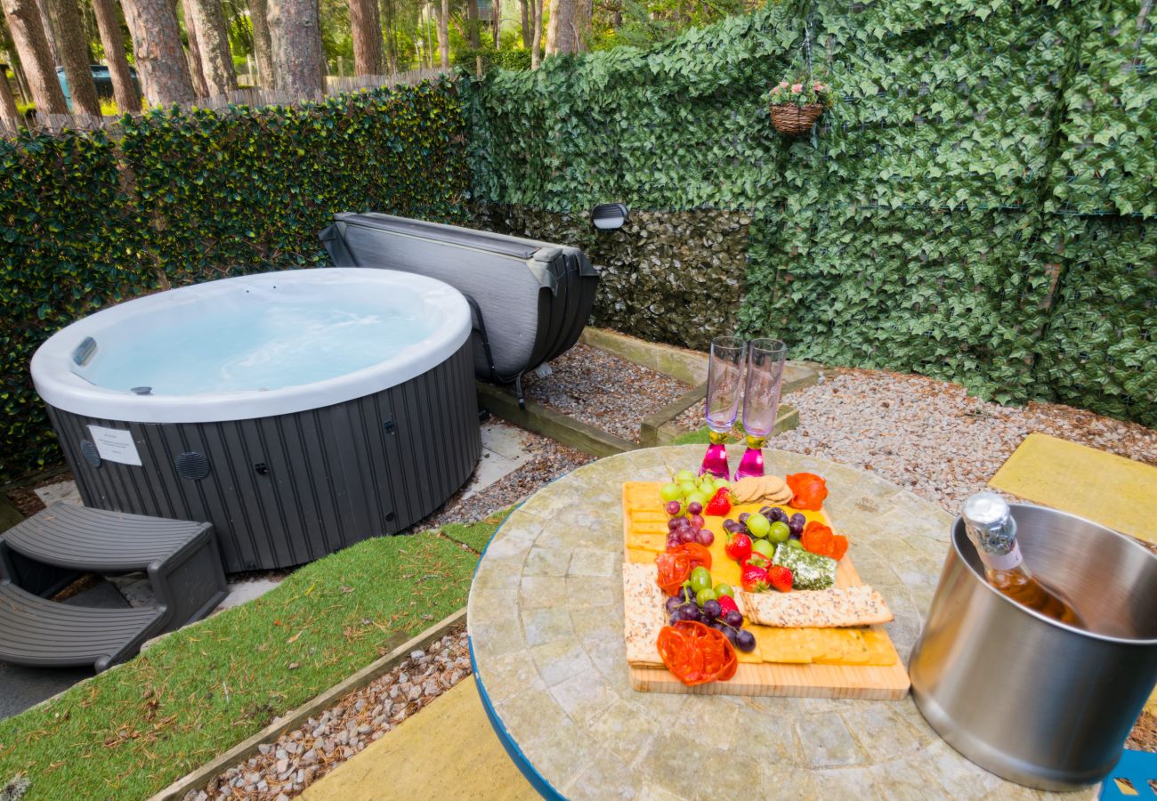 Outdoor hot tub with grazing platter and chilled fizz at Wildcat Lodge, a couples retreat in Boat of Garten, Cairngorms
