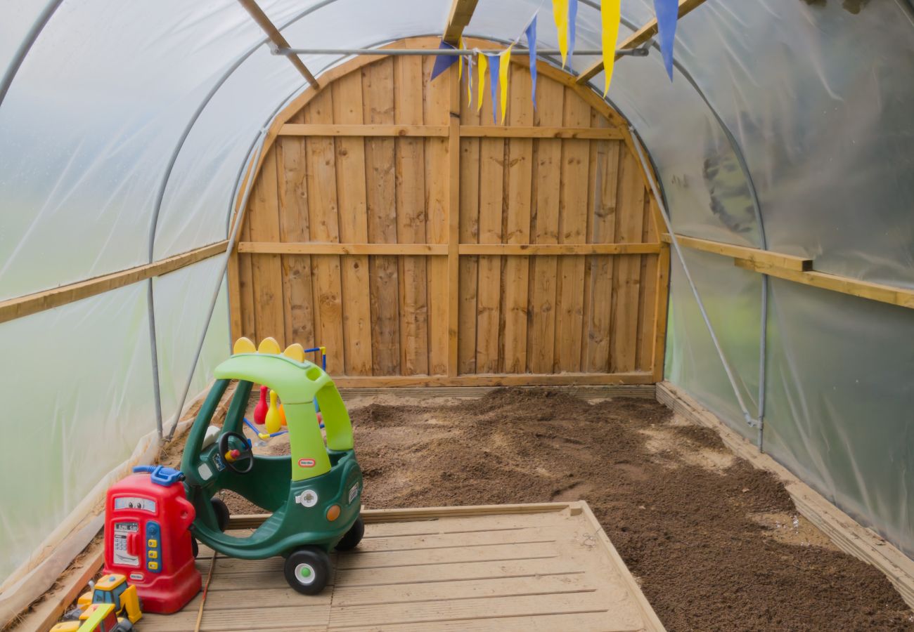 Polytunnel with children's ride-on toys and bunting at Kinloch Lodge, Balnain near Drumnadrochit