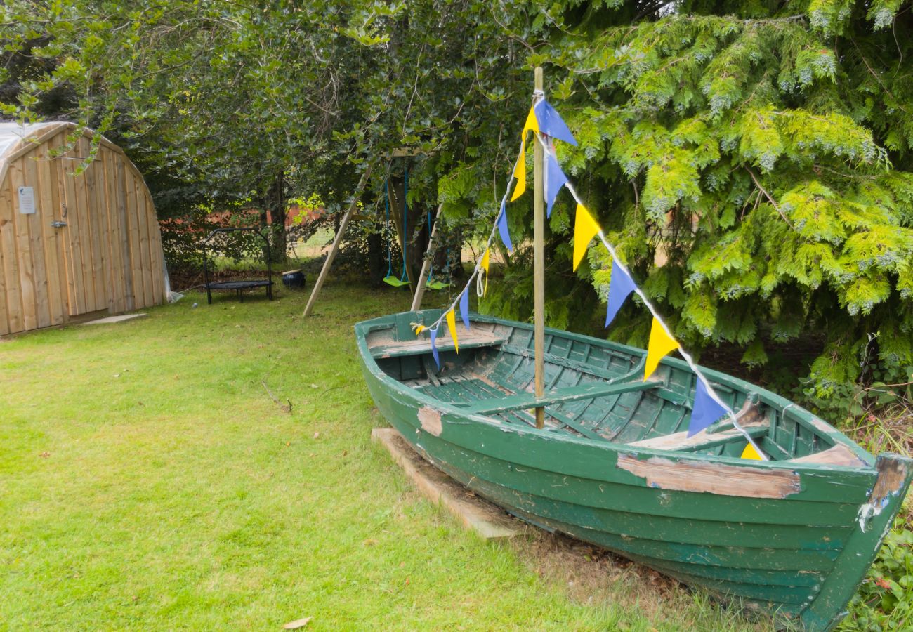 Green rowing boat with bunting on the lawn in the garden at Kinloch Lodge, Balnain near Drumnadrochit