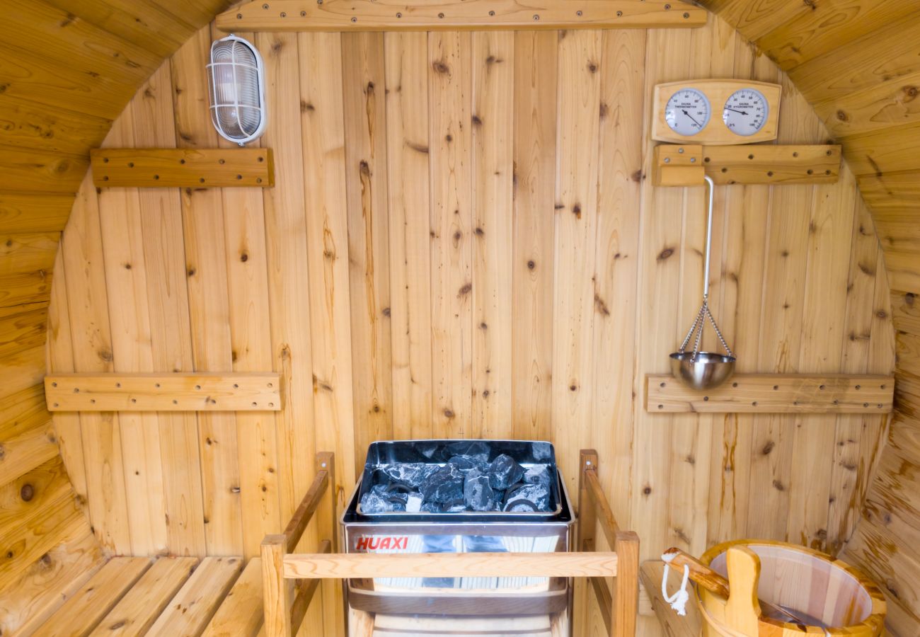Interior of the timber barrel sauna with stove, bucket and ladle at Kinloch Lodge, Balnain near Drumnadrochit