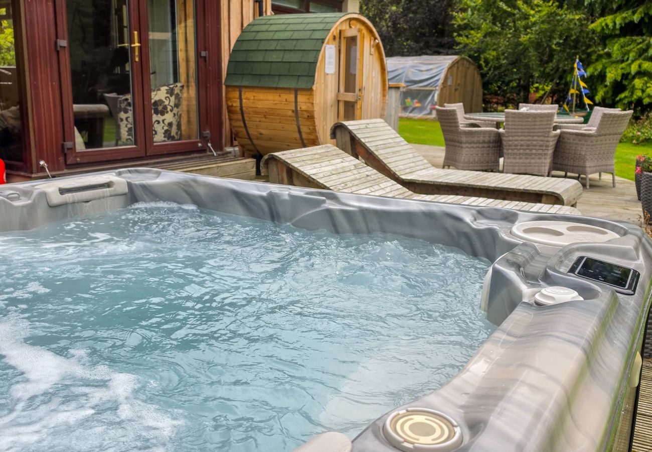 Bubbling hot tub beside the barrel sauna and sun loungers at Kinloch Lodge, Balnain near Loch Ness