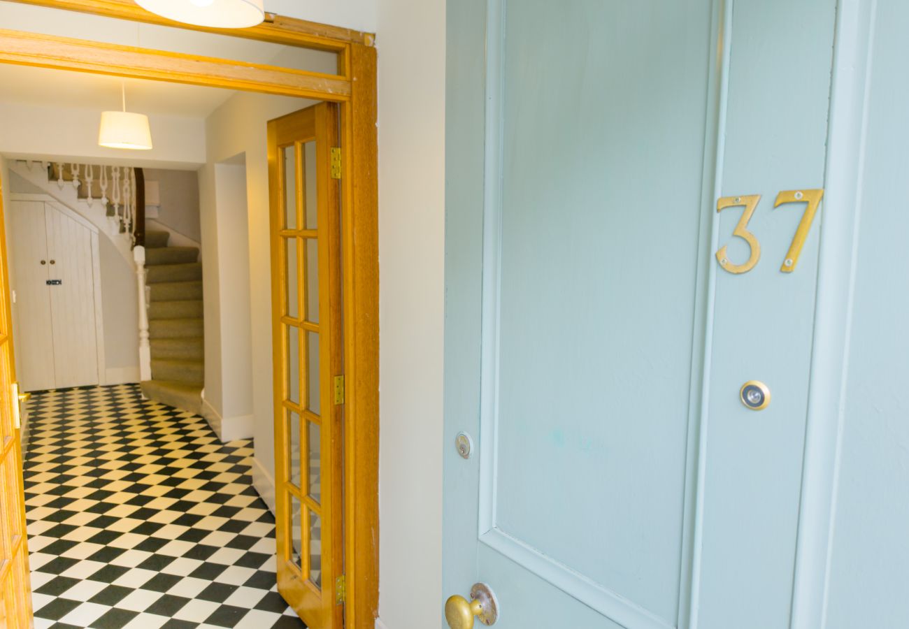 Blue front door numbered 37 opening onto a tiled hallway at Twinflower, High Street, Grantown-on-Spey