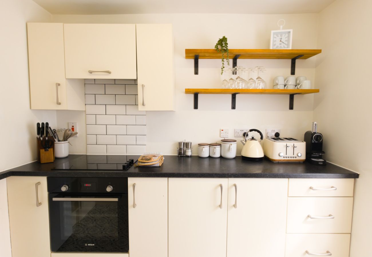 Kitchen with cream units, dark worktop and open shelving at Twinflower townhouse, Grantown-on-Spey