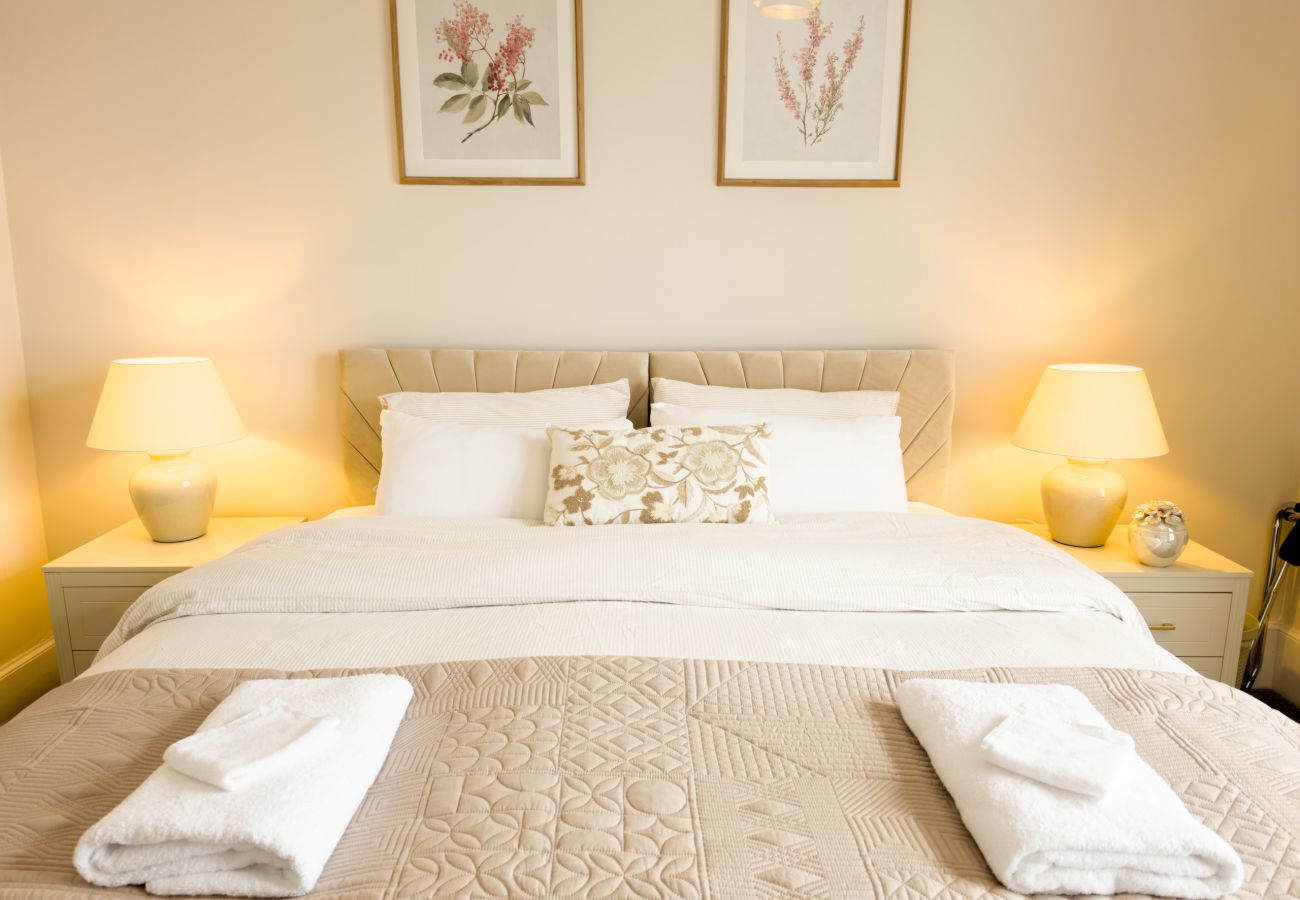 Double bed with padded headboard, bedside lamps and botanical prints at Twinflower, Grantown-on-Spey
