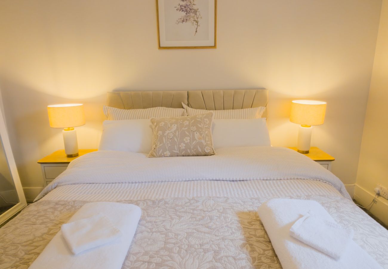Made-up double bed with lamps either side and folded towels at Twinflower, Grantown-on-Spey, Strathspey