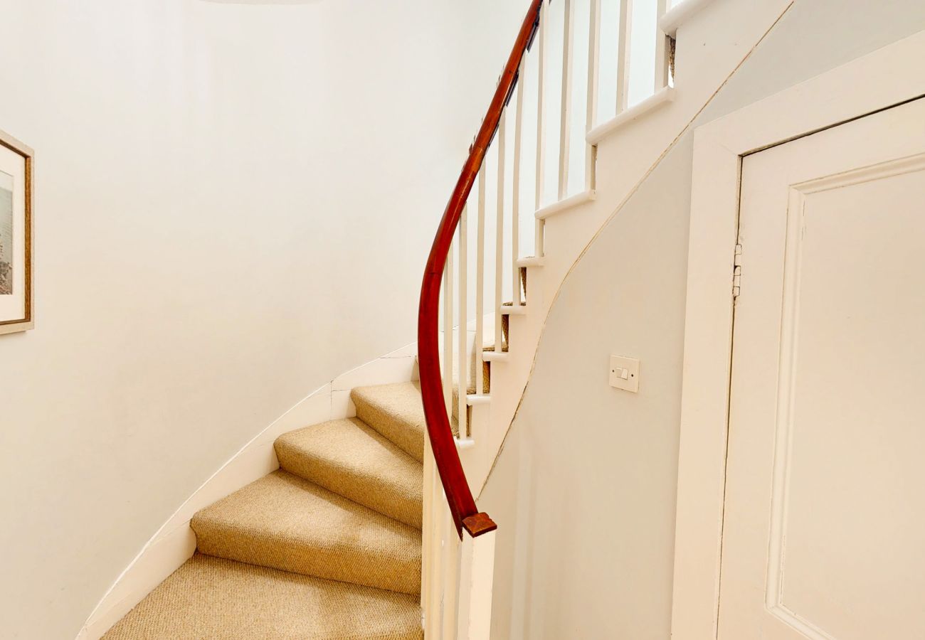 Carpeted stairs and landing doors with a framed picture at Twinflower, Grantown-on-Spey, Cairngorms