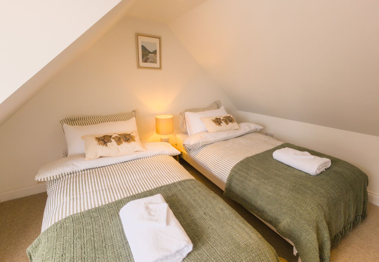 Twin beds under a sloping attic ceiling at Twinflower townhouse, Grantown-on-Spey, Cairngorms